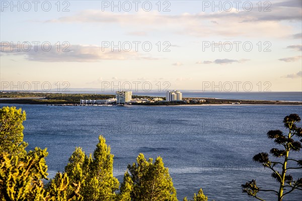 Cityscape of Troia by sunset with Atlantic ocean and trees in the foreground