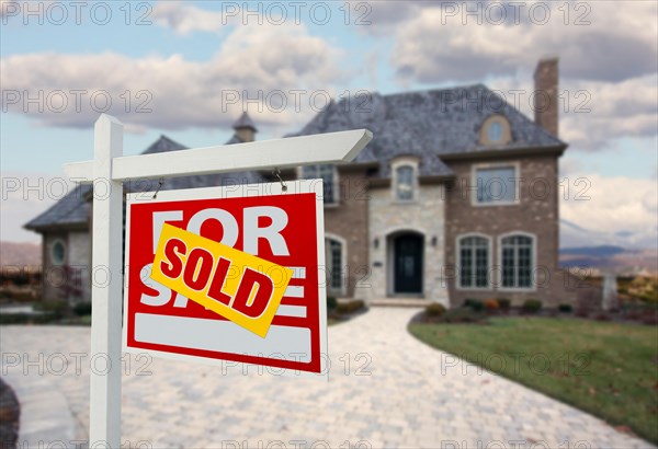 Sold home for sale sign in front of beautiful new house