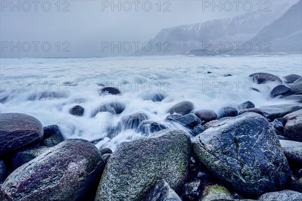 Waves of Norwegian sea surging on stone rocks at Unstad beach