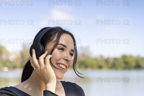 Young woman listening to music outdoors with headphones. Expression of happiness