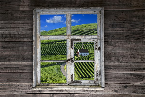 View through a rustic wooden window of the chapel in the vineyards