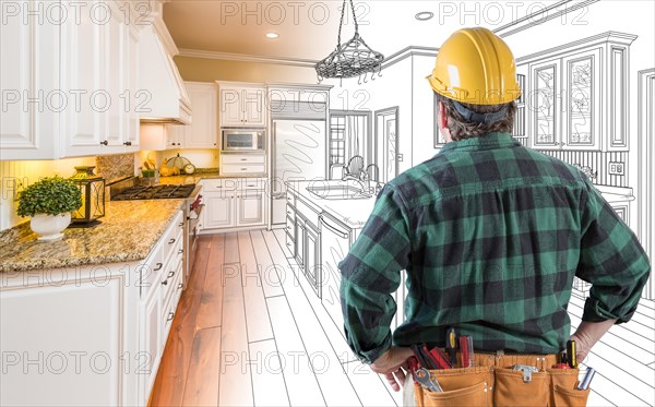 Male contractor with hard hat and tool belt looking at custom kitchen drawing photo combination on white