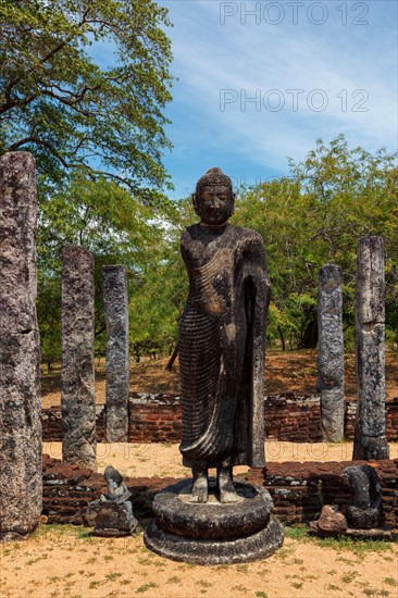 Stainding Buddha statue in ancient ruins