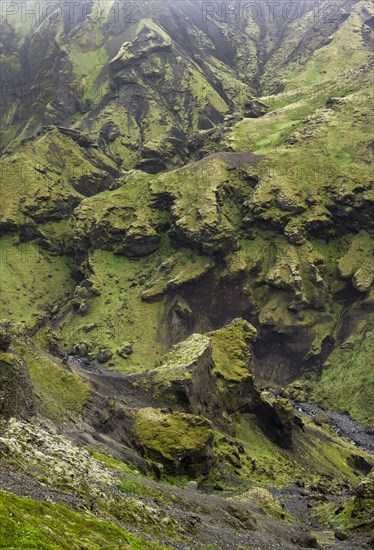 View into rugged moss-covered canyon with tufa rock formations