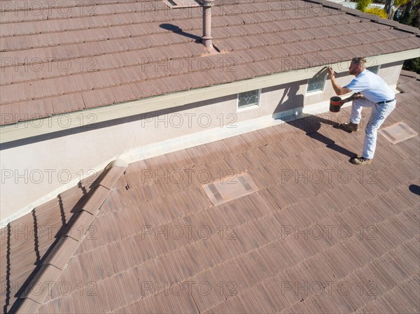 Professional painter using A brush to paint house facade