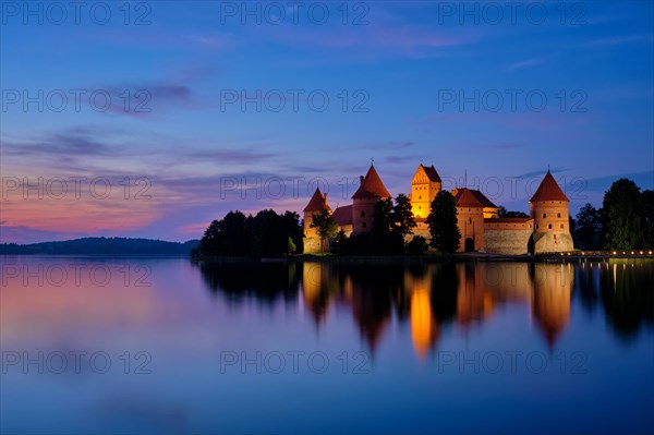 Night view of Trakai Island Castle in lake Galve illuminated in the evening reflecting in peaceful water