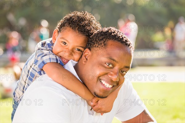 Happy african american father and mixed-race son playing at the park