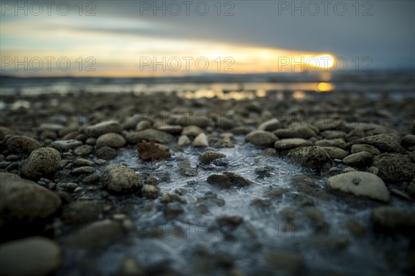 Sunrise on a wintry lake in bad weather