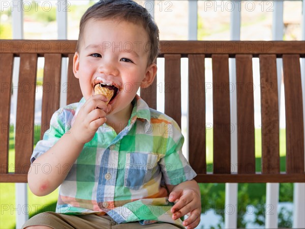 Young mixed-race chinese and caucasian boy enjoying his ice cream cone