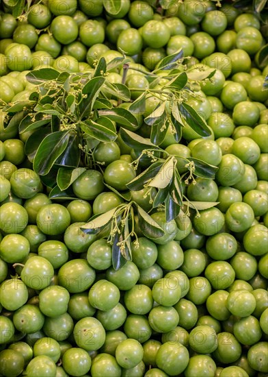 Green unripe plums in bazaar market place