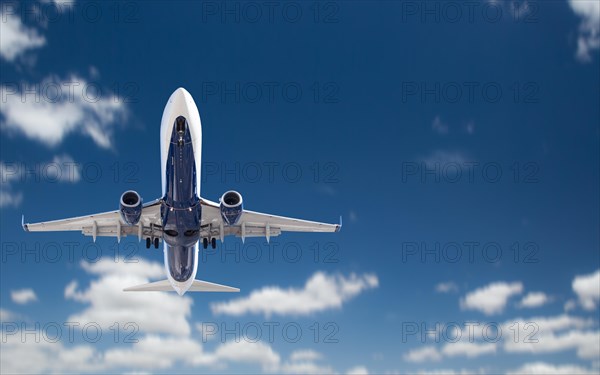 Bottom view of passenger airplane flying in the blue sky