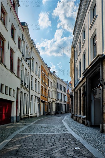 Antwerp cobblestone street with alley row of medieval houses at the old European city port