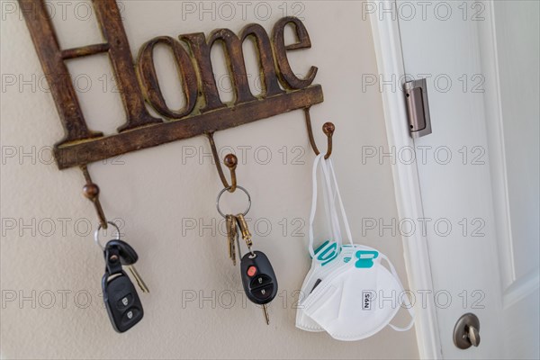Home key hanger rack next to door with keys and medical face mask during coronavirus pandemic