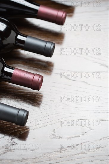 Various wine bottles on a reflective wood surface abstract