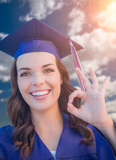 Happy graduating mixed-race woman in cap and gown