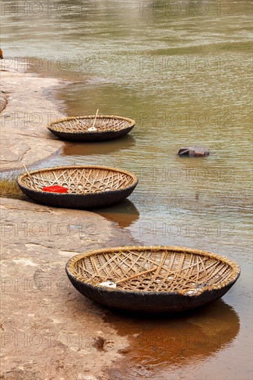 Traditional wickerwork coracle boat in Hampi on bank of Tungabhadra river