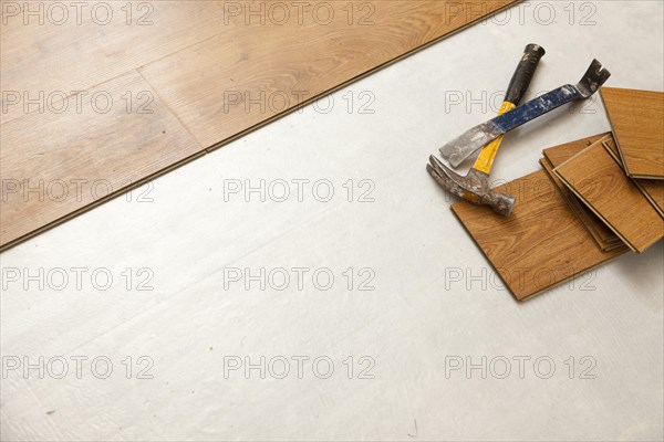 Worn hammer and pry bar with laminate flooring abstract with copy room