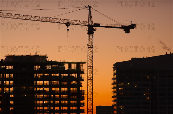 Silhouette of crane and building construction site
