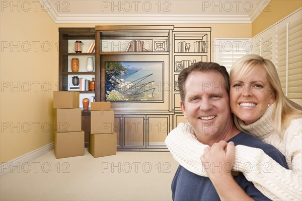 Young couple in room with moving boxes and drawing of entertainment unit on wall