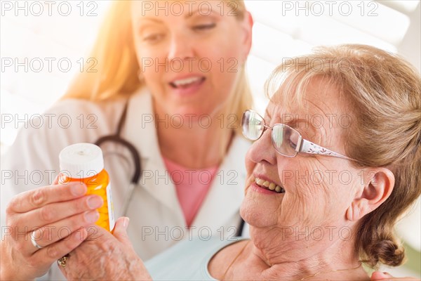 Happy female doctor or nurse explaining prescription to senior adult woman