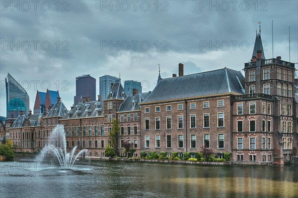 View of the Binnenhof House of Parliament and the Hofvijver lake with downtown skyscrapers in background