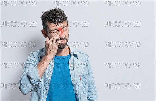 Person with pain touching nose. A person with nasal bridge pain