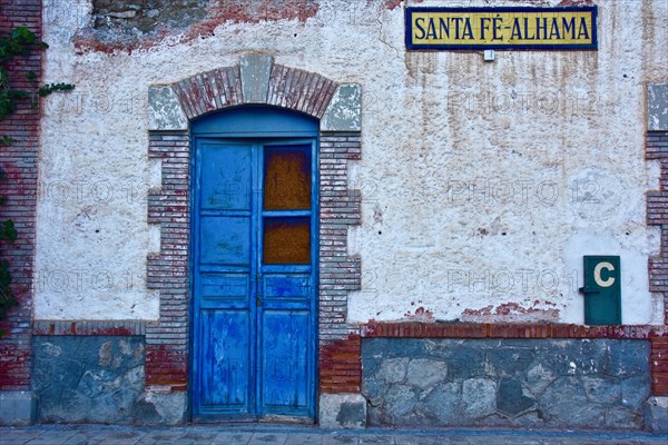 Blue nailed door framed by bricks at closed station