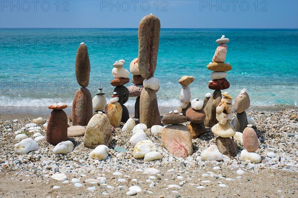 Concept of balance and harmony. Stones pebbles stacks on the beach coast of the blue sea in the nature. Meditative art of stone stacking