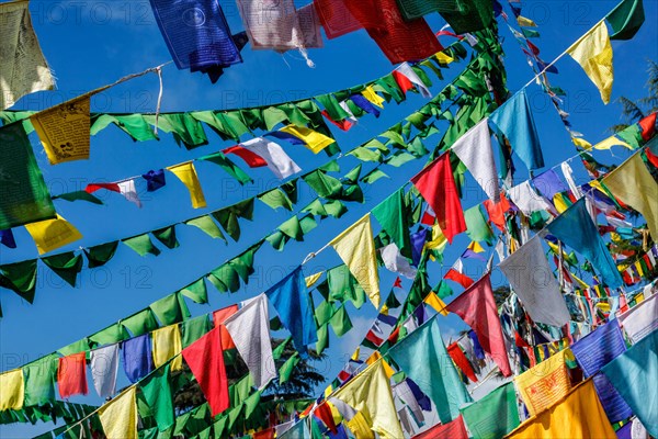 Buddhist prayer flags lungta with Om Mani Padme Hum Buddhist mantra prayer meaning Praise to the Jewel in the Lotus on kora around Tsuglagkhang complex