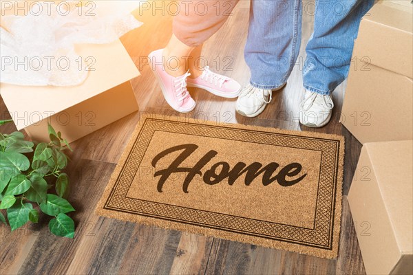 Man and woman unpacking near home welcome mat