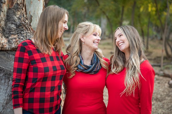 Beautiful mother and young adult daughters portrait outdoors