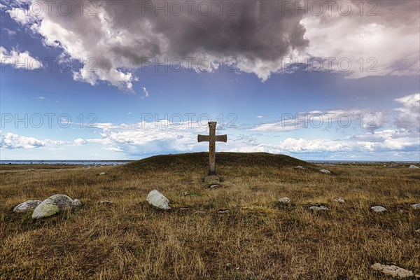Stone cross in a barren meadow