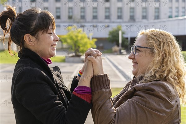 Latina lesbian female couple holding hands in a park