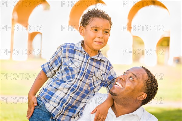 Happy african american father and mixed-race son playing at the park