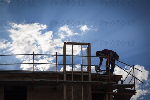 Construction worker silhouette on roof of building