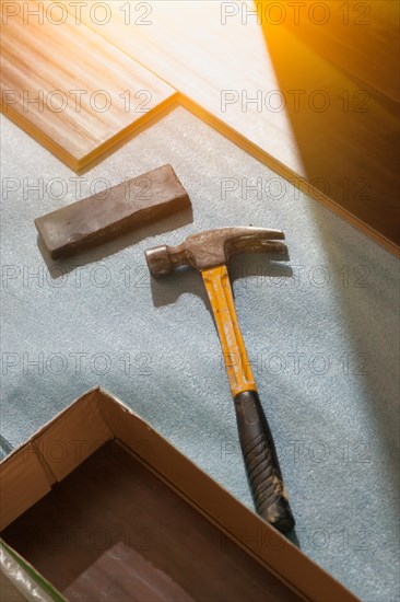 Hammer and block with new laminate flooring abstract