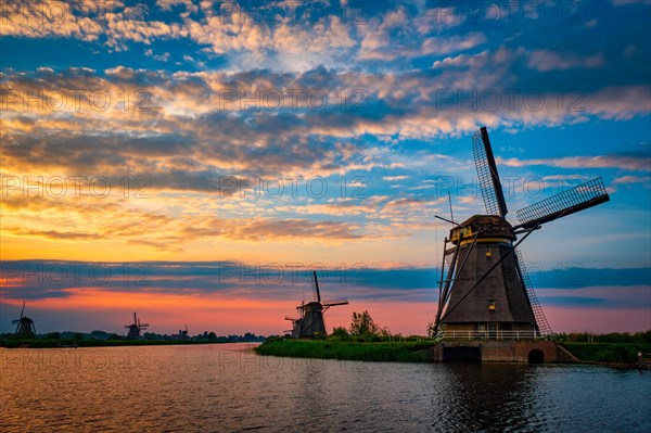 Netherlands rural landscape with windmills at famous tourist site Kinderdijk in Holland on sunset with dramatic sky