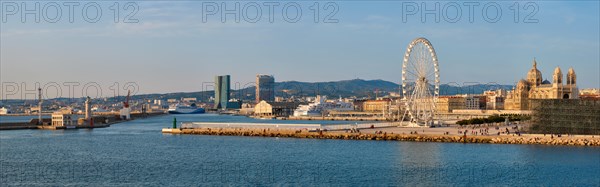 Panorama of Grande Roue de Marseille Ferris wheel and Marseille cathedral and port of Marseille on sunset