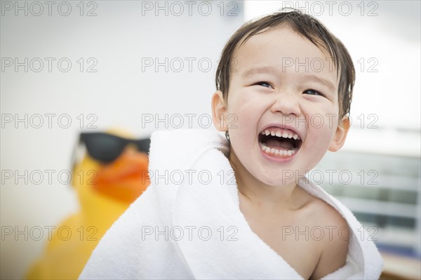 mixed-race boy having fun at the water park with large rubber duck in the background