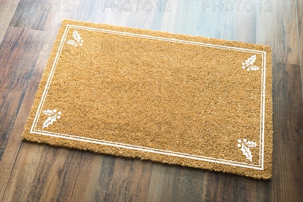 Blank holiday welcome mat with holly on wood floor background