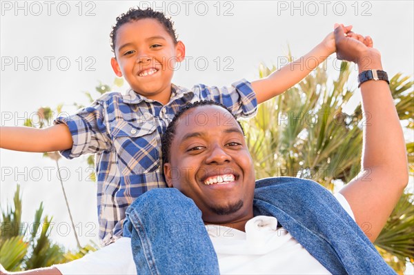 Happy african american father and mixed-race son playing at the park