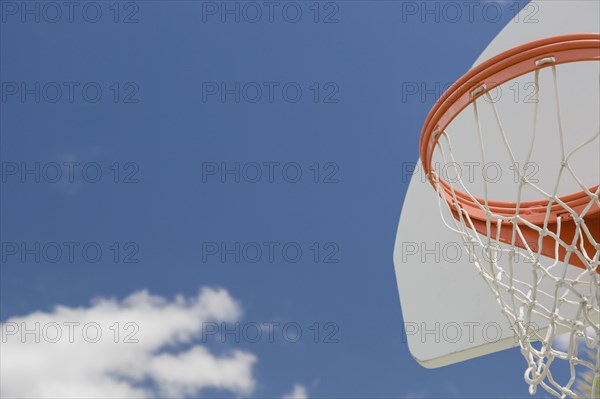 Abstract of community basketball hoop and net against blue sky