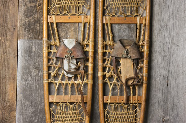 Antique snowshoes on rustic cabin wall