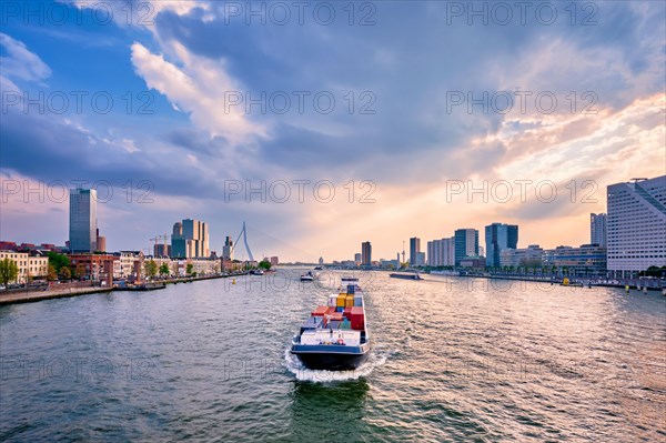 View of Rotterdam cityscape and Erasmus bridge over Nieuwe Maas with cargo ships and boats