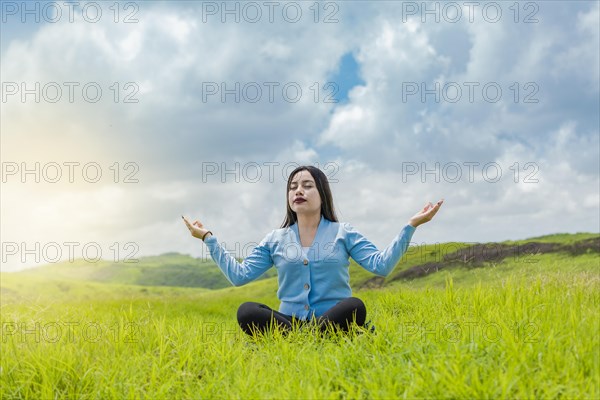 Girl sitting doing meditation yoga in the field