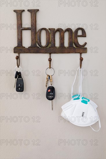 Home key hanger rack next to door with keys and medical face mask during coronavirus pandemic