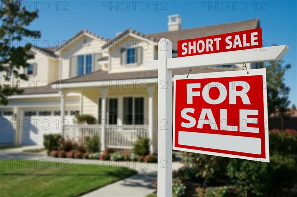 Short sale home for sale real estate sign in front of new house