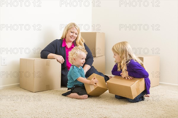 Happy young family in empty room with moving boxes