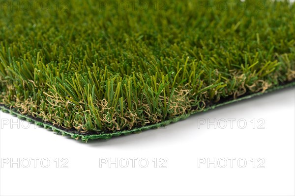 Section of artificial turf grass on white background