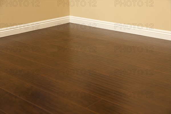 Beautiful newly installed brown laminate flooring and baseboards in home